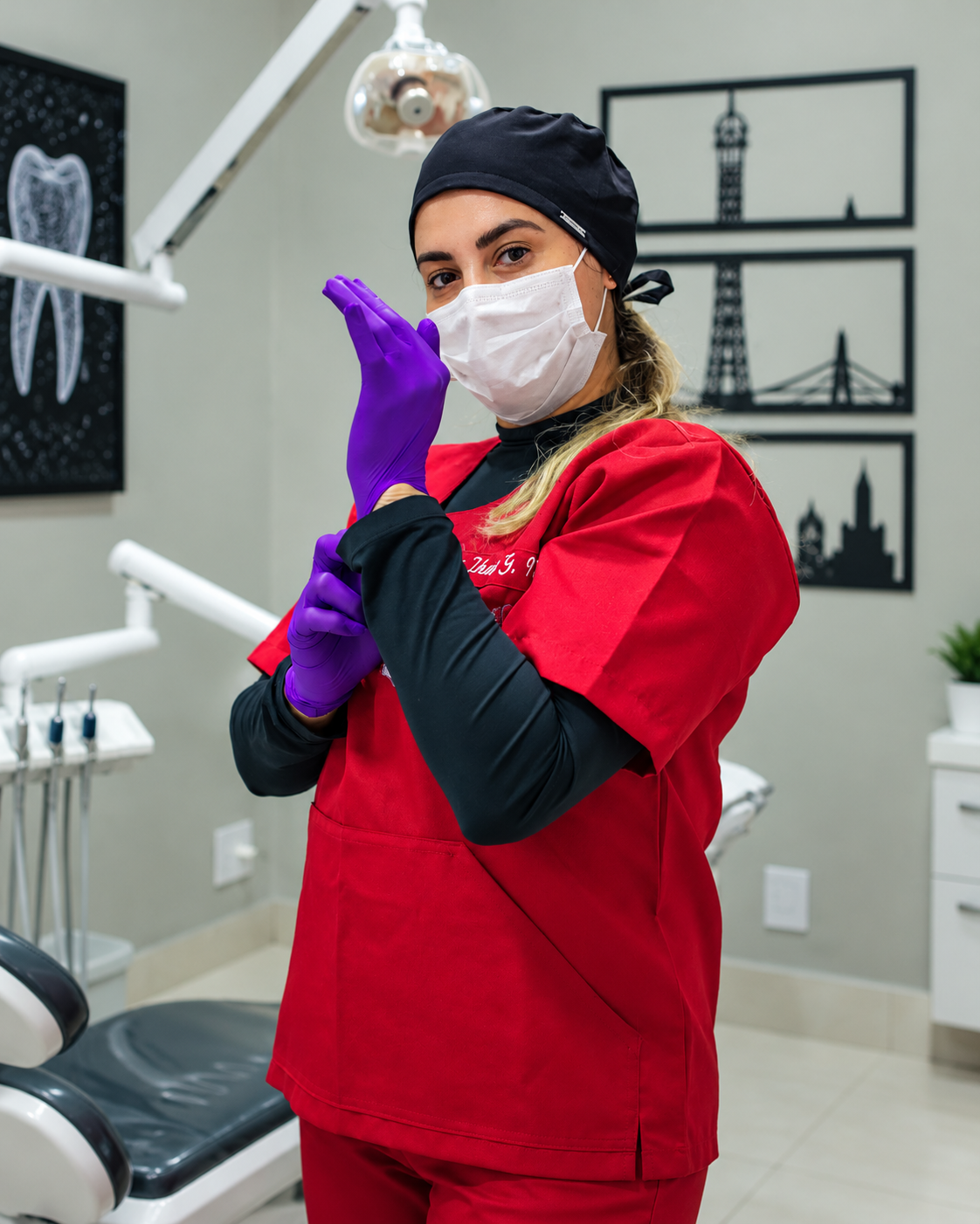 Profissional odontológica ajustando luvas no consultório